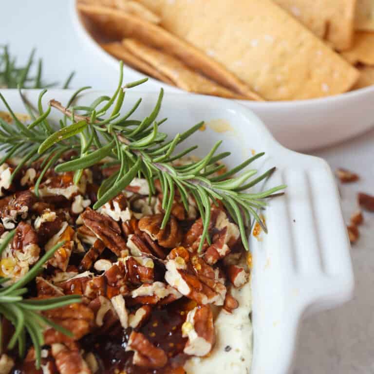 Baked Goat Cheese topped with fig jam, chopped pecans, honey, and fresh rosemary