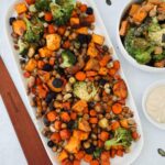 Roasted vegetable bowl with rainbow carrots, broccoli, sweet potato, and crispy chickpeas, served with tahini dressing