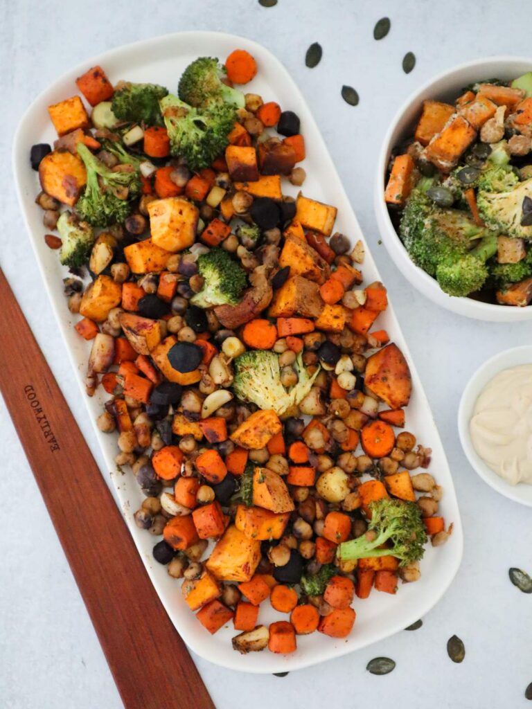 Roasted vegetable bowl with rainbow carrots, broccoli, sweet potato, and crispy chickpeas, served with tahini dressing